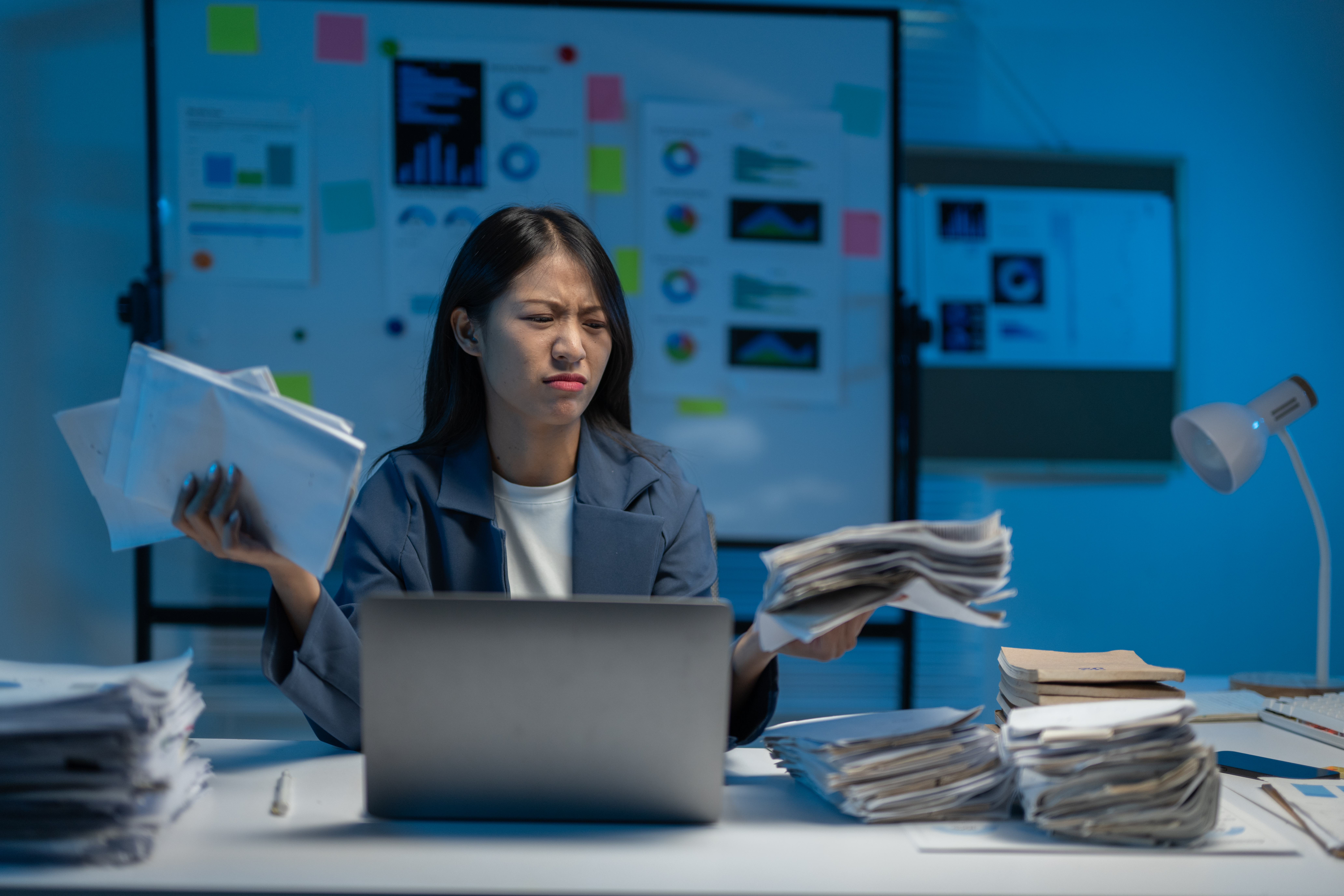 woman stressed with paper invoices